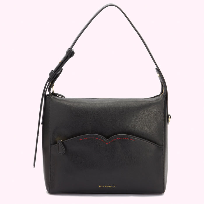 Front image of a black leather shoulder bag with a curved front pocket with contrasting red stitching.
