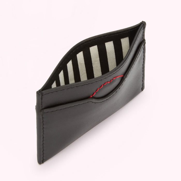 Black leather cardholder open to reveal a black and white striped interior with red stitching.