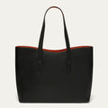 A black pebbled leather tote bag with dual shoulder straps and a contrasting red interior lining, shown against a plain off-white background.
