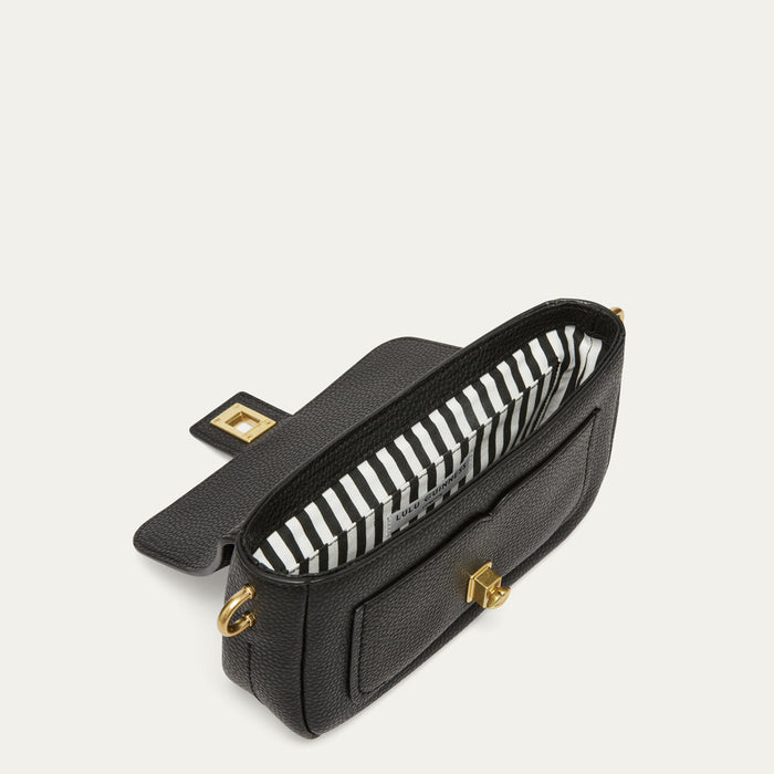 A black textured leather handbag with a black and white striped interior lining and gold-tone hardware, shown open on a light off-white background.