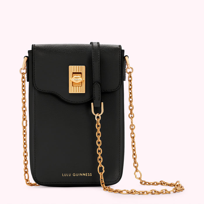 Black Lulu Guinness crossbody bag with gold chain strap and lip-shaped clasp.