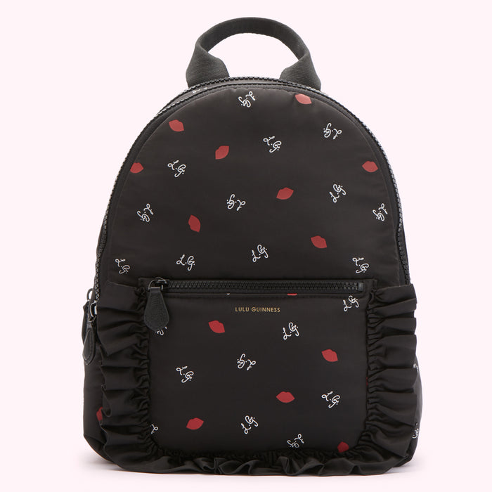 Black Lulu Guinness backpack with red lips and white L.G. logo print, and black ruffle trim.