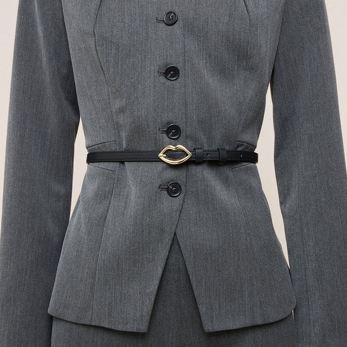 Women in a grey suit wearing a black leather waist belt with a gold lip shaped  buckle.