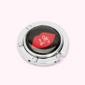 Silver handbag hook with a black and red lip design.