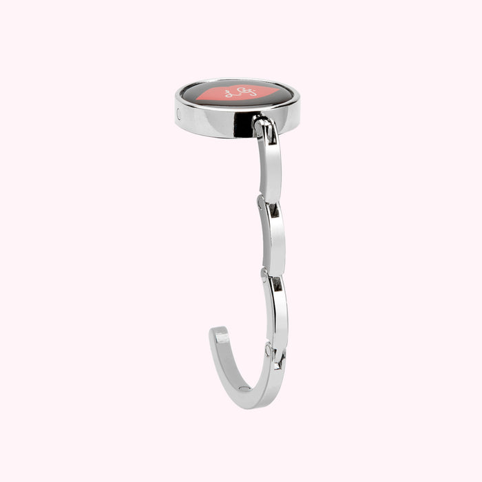 Silver retractable handbag hook with a circular red lip design on the top.