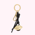 Gold lip-shaped keychain with black leather accents.