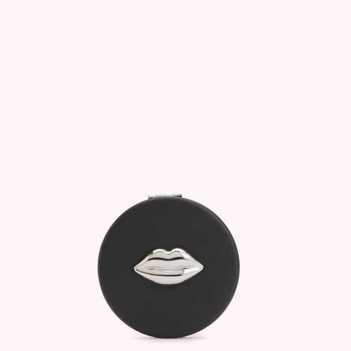 Black round compact mirror with silver lip design.