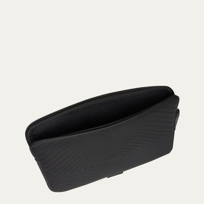 Black laptop sleeve with lip shaped quilting on a light gray background
