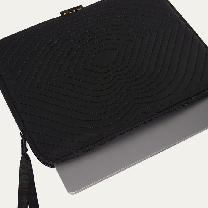 Black laptop sleeve with lip shaped quilting on a light gray background