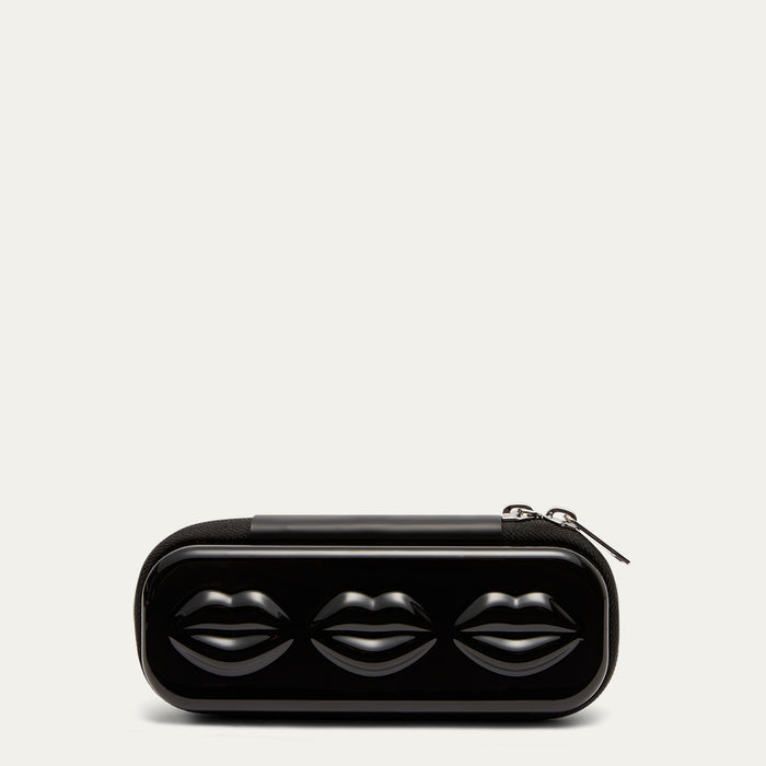 Black sunglasses case with lip details and silver zips on a grey background.