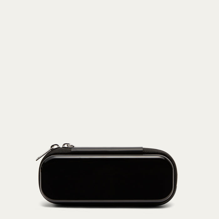 Back of a black sunglasses case with  silver zips on a grey background