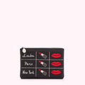 Black makeup bag with embroidered lipsticks and lips, and the words London, Paris, and New York.