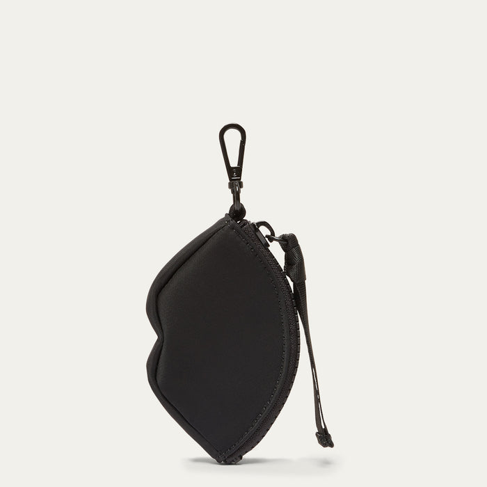 Black lip shaped charm on a light grey background