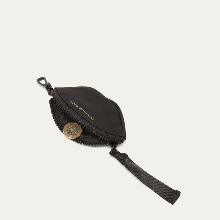 Black pouch with a coin on a light grey background