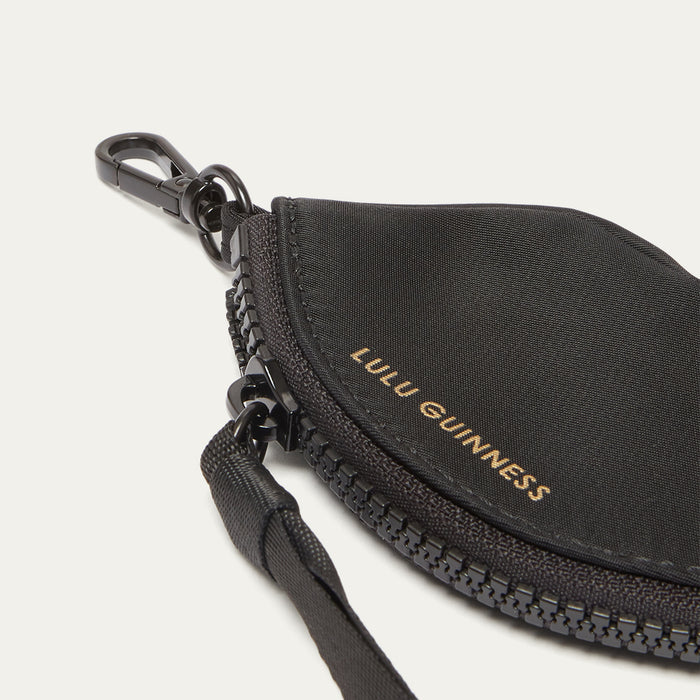 Black keychain pouch with 'Lulu Guinness' branding on a light grey