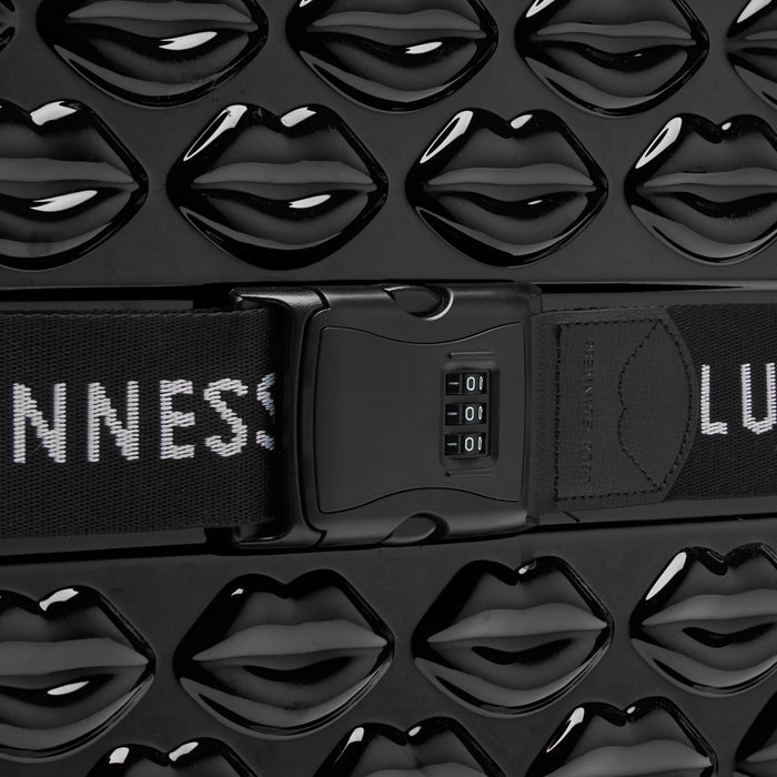 Close-up of a black suitcase with a lip print design and a combination lock.