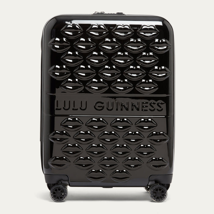 Black suitcase with a lip pattern and Lulu Guinness branding on a white background