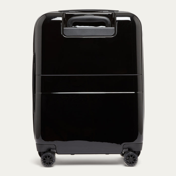 Black suitcase with wheels on a light gray background