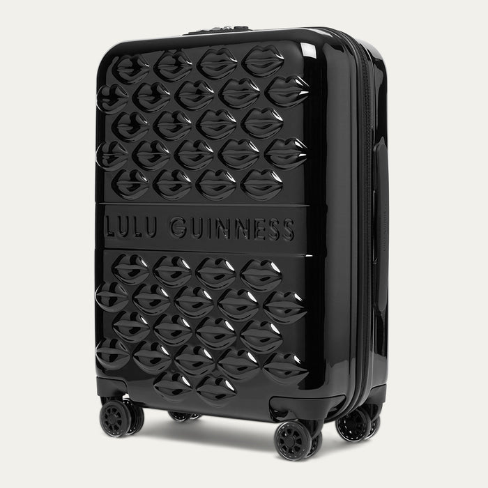 Black suitcase with Lulu Guinness branding on a light gray background