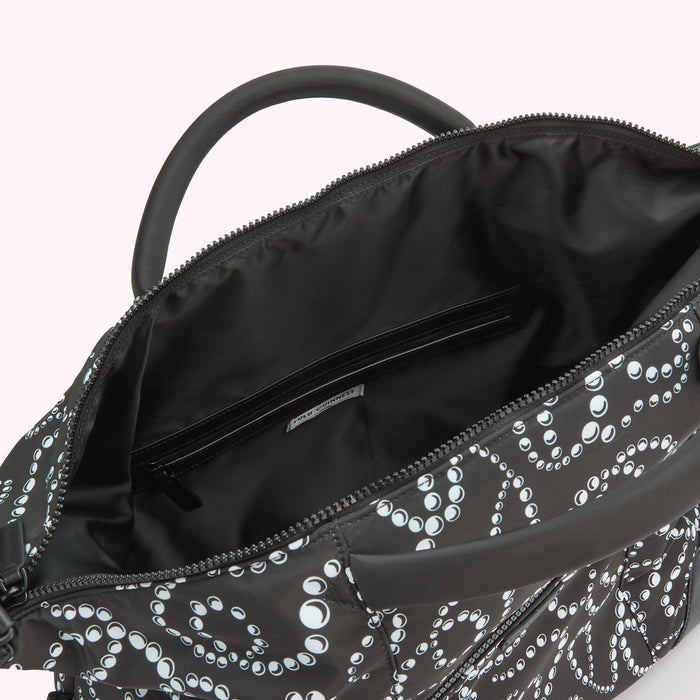 Inside of a black Lulu Guinness holdall bag with a white pearl pattern.
