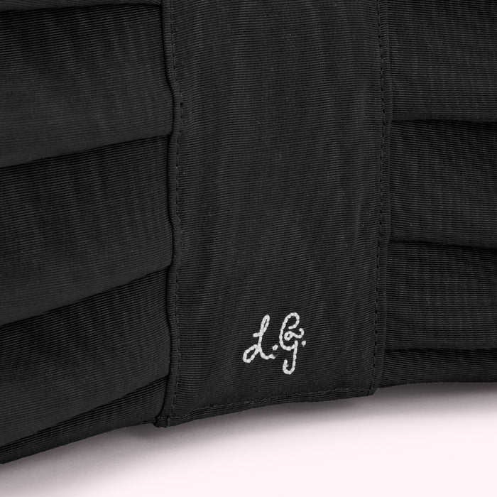 Close-up of a black fabric item with the initials "L.G." embroidered on it.