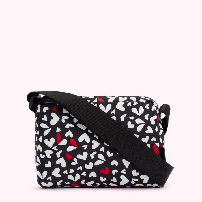Black crossbody bag with a white and red heart pattern.