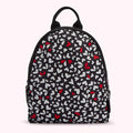 Black backpack with a pattern of white and red hearts.