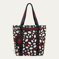 Tote bag with red and white lip flurry print and 'Lulu Guinness' branding with a detachable lip print pouch on a white background