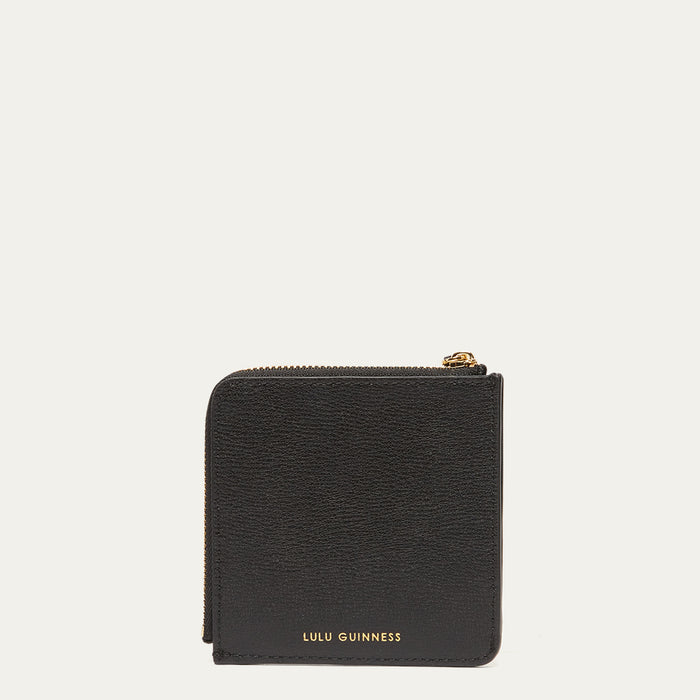 Black wallet with gold zipper and 'Lulu Guinness' branding on a light grey background