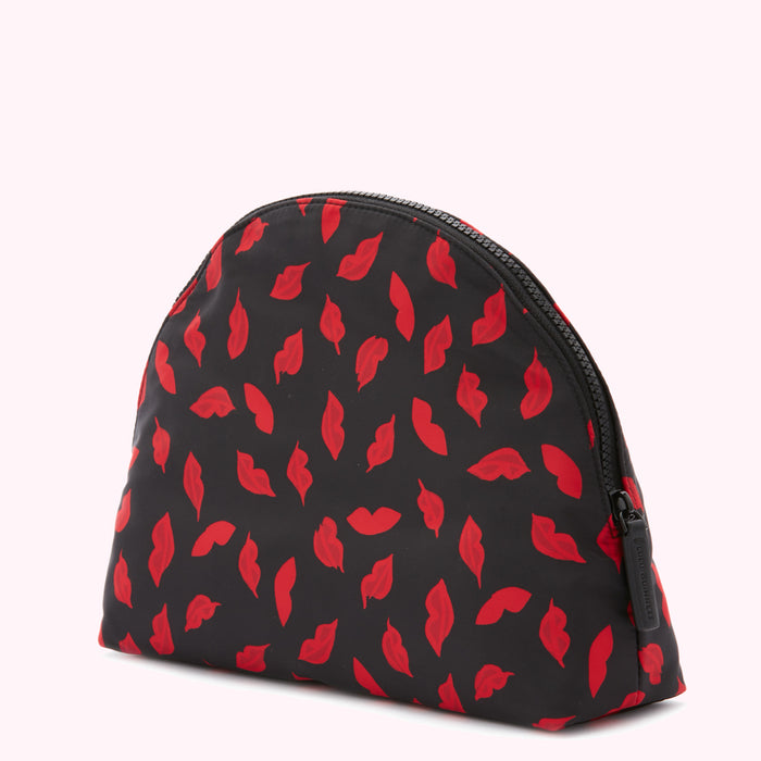 Black half-moon shaped cosmetic bag with a red lips print and zipper closure.