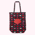Black tote bag with red lips pattern and a red lip-shaped coin purse.