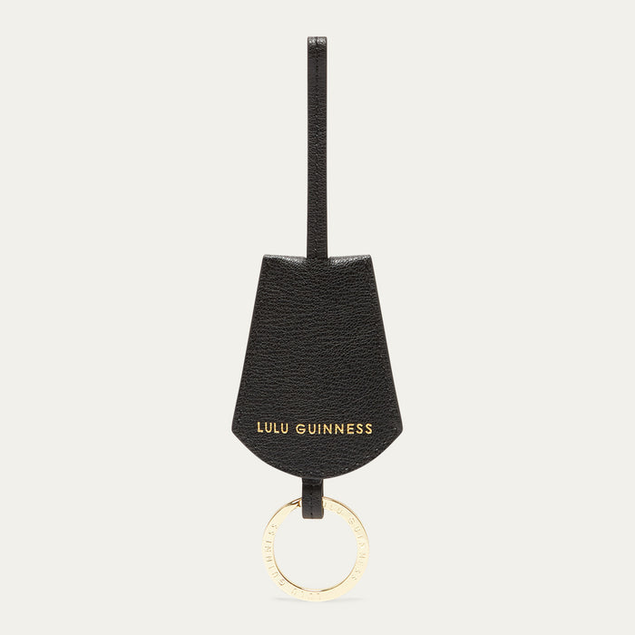 Black keychain with gold ring and 'Lulu Guinness' branding on a white background
