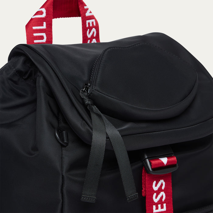 Black backpack with red and white 'Lulu Guinness' straps on a light grey background