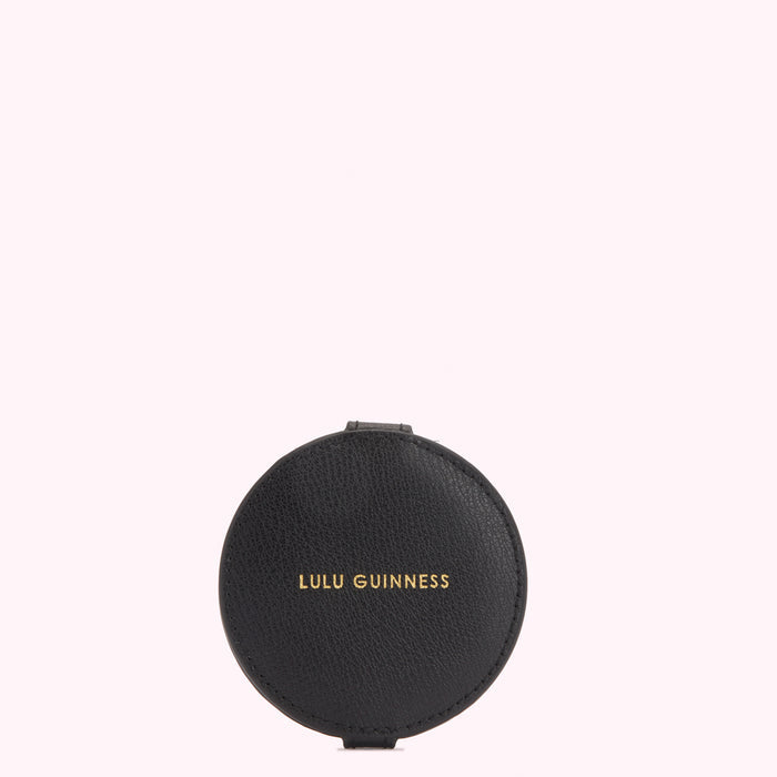 Black round compact mirror with gold Lulu Guinness logo on a white background.