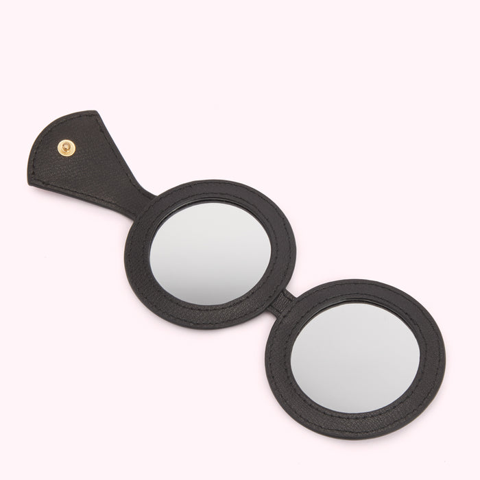 Black double-sided compact mirror with a leather handle.