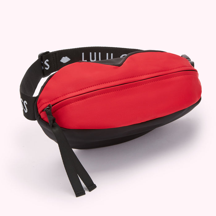 Red and black lip-shaped waist bag with "Lulu Guinness" across the strap.
