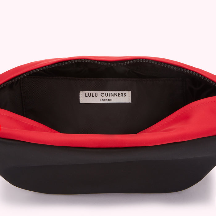 Inside of a black and red Lulu Guinness Lip belt bag.