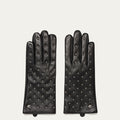 Pair of black leather gloves with studded details on a light gray background