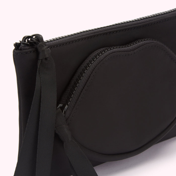 Close-up of a black neoprene pouch with a lip-shaped zippered pocket and a black fabric tassel.