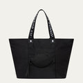 Black tote bag with Lulu Guinness handles and a lip-shaped pocket on a light grey background