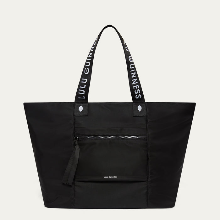 Black tote bag with 'Lulu Guinness' branding on a light grey background