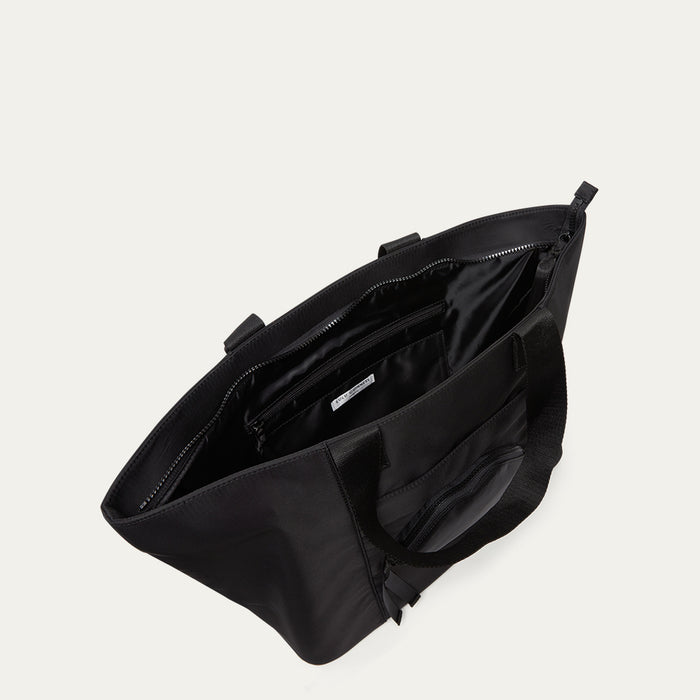 Black bag with open front compartment on a light grey background
