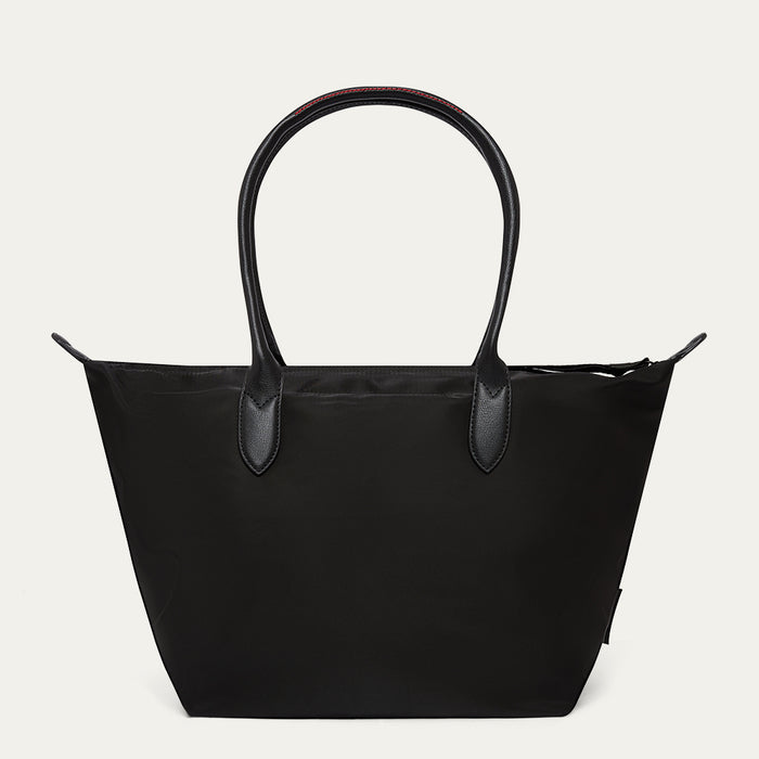 Black tote bag with leather handles on a light grey background
