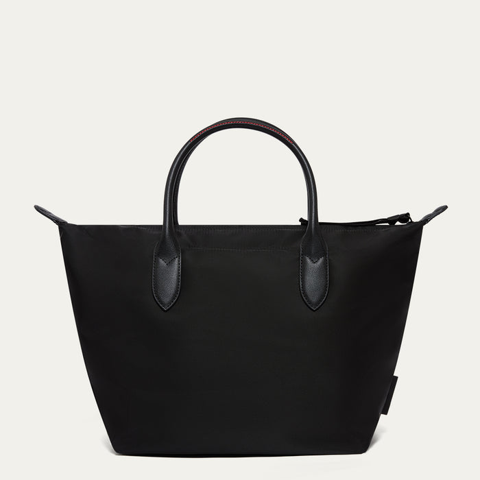 Black tote bag with leather handles on a light gray background