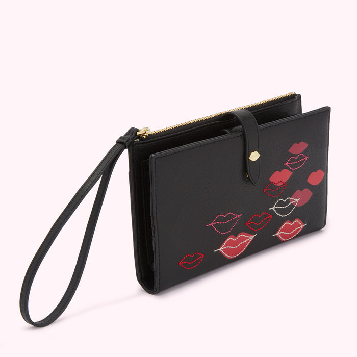 Black leather wallet with wrist strap and embroidered lips.