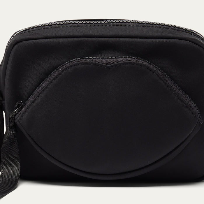Black crossbody bag with a lip-shaped pocket on a white background