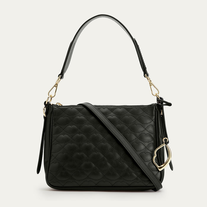 Black quilted handbag with gold accents on a light gray background