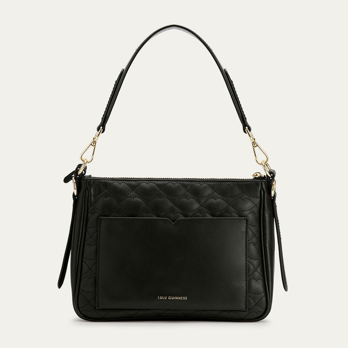 Black quilted handbag with gold accents on a light gray background