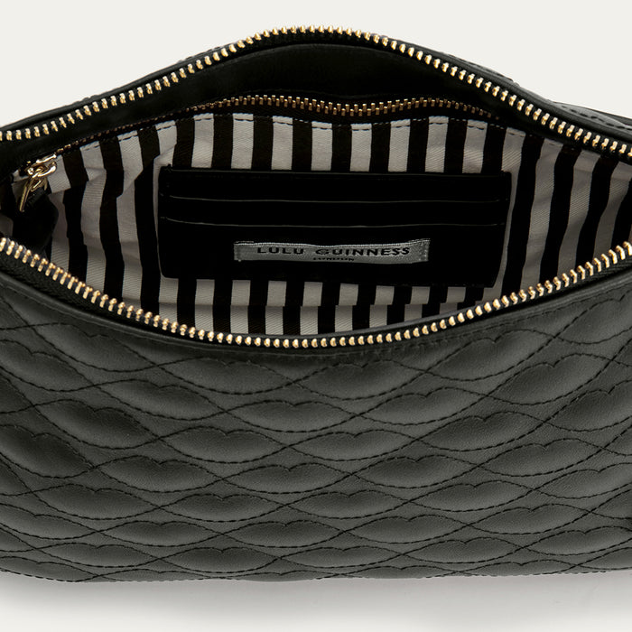 Black quilted handbag with striped lining on a white background