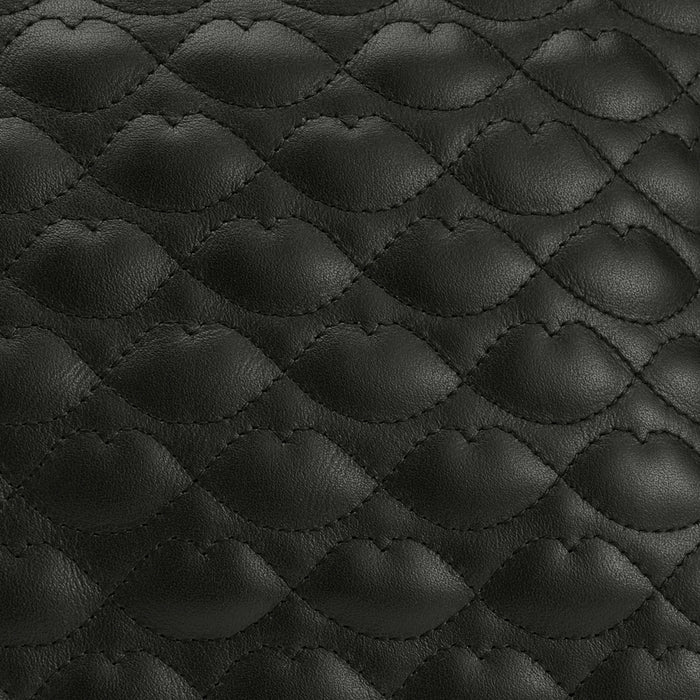 Close-up of black quilted leather with a wave pattern.